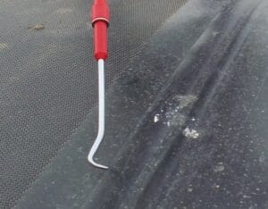 NDL vs. Material-Only Coverage: Commercial roof inspector checking single ply TPO seam with probe tool during NDL audit